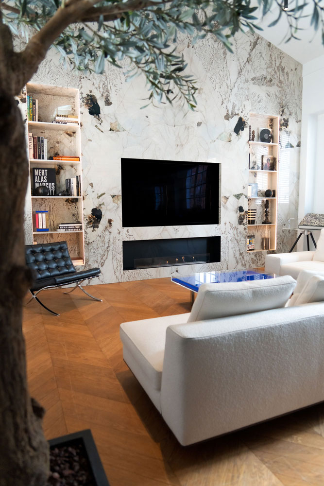 Cheminee-sur-mesure-dans-du-marbre-home Custom-built fireplace set into a marble wall with television